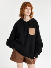 A lady wears a black hoodie.